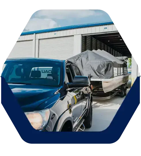 Truck pulling a covered pontoon boat into a drive-up storage unit at Battle Creek Storage in Broken Arrow, OK